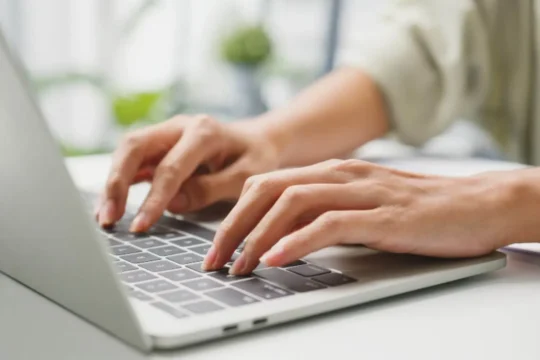 Mulher mexendo no notebook para simular empréstimo online.
