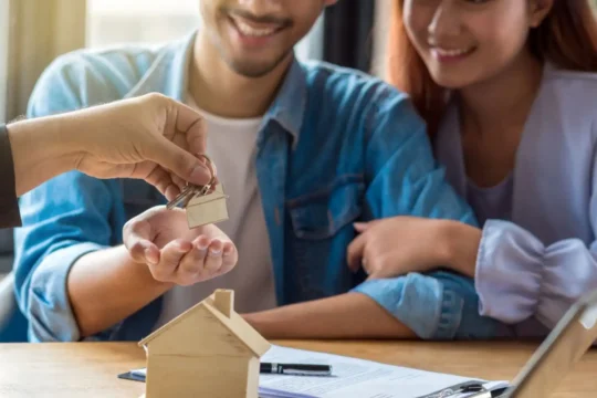 Casal assinando contrato de empréstimo, representando como funciona o home equity.