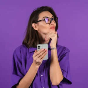 Mulher pensativa segurando smartphone em fundo roxo, ilustrando um artigo da BK Open sobre bancos tradicionais.