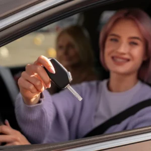 Mulher sorridente segurando chave de carro dentro do veículo com passageira ao fundo, ilustrando um artigo da BKOpen sobre qual melhor consórcio do Brasil.